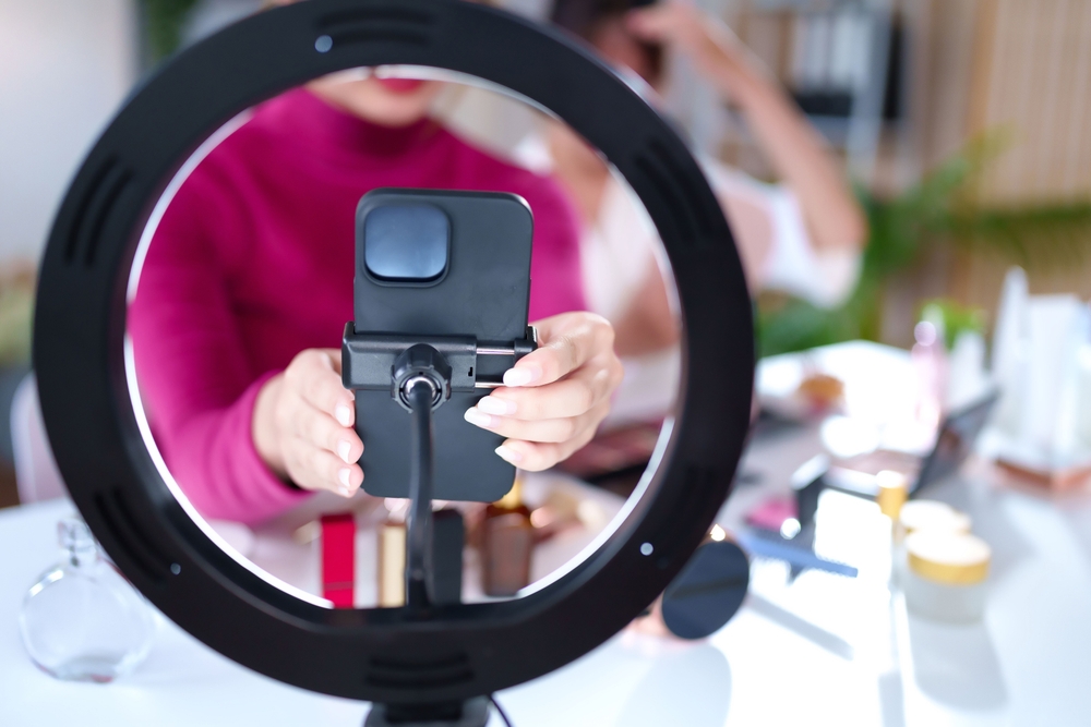 Asian,young,woman,hands,hold,phone,setup,with,ring,light