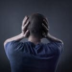 Teenage,boy,with,his,hands,covering,his,ears,and,holding