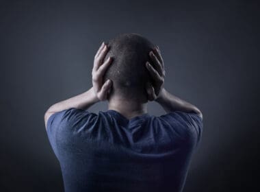 Teenage,boy,with,his,hands,covering,his,ears,and,holding