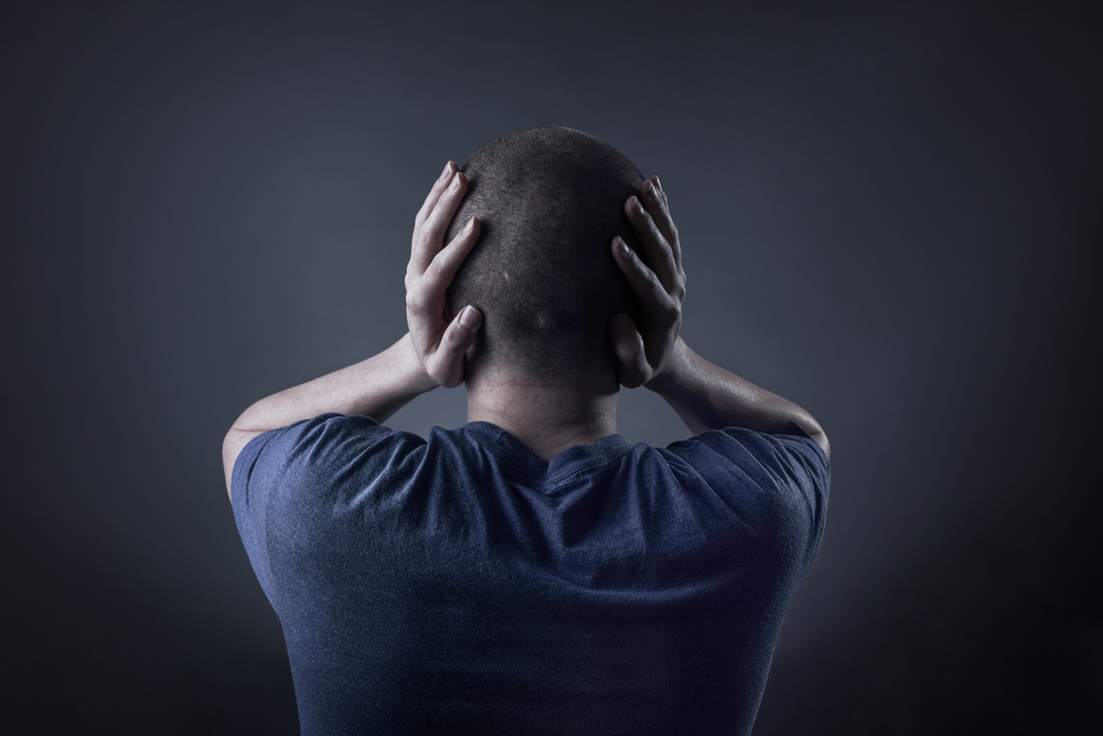 Teenage,boy,with,his,hands,covering,his,ears,and,holding