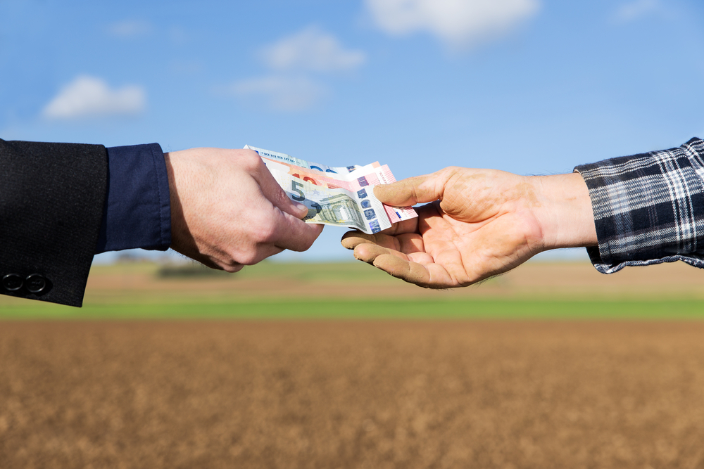 A,businessman,and,farmer,with,a,money,transfer