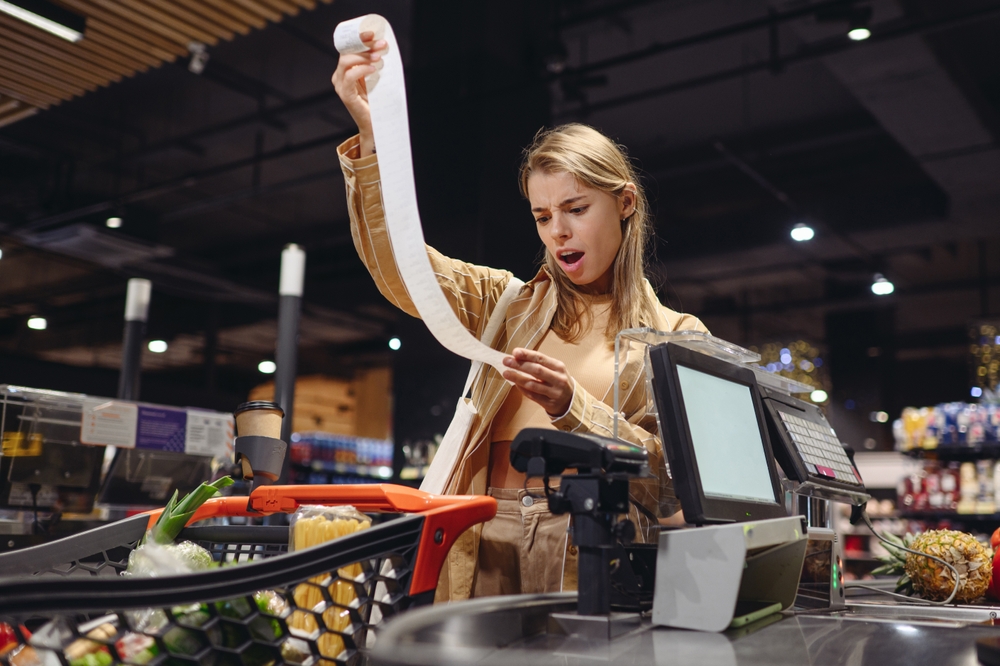 Young,sad,customer,woman,wears,casual,clothes,read,bill,at