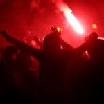 Football,fans,cheer,with,lighted,torches,during,the,match