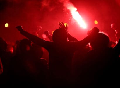 Football,fans,cheer,with,lighted,torches,during,the,match