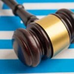 Greece,legal,,justice,and,agreement,,wooden,court,gavel,on,flag