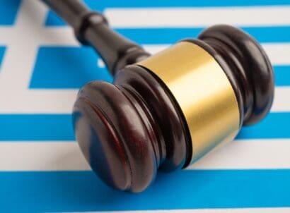 Greece,legal,,justice,and,agreement,,wooden,court,gavel,on,flag