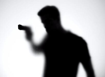 Shadow,of,male,killer,aiming,gun,through,glass,wall,,contract
