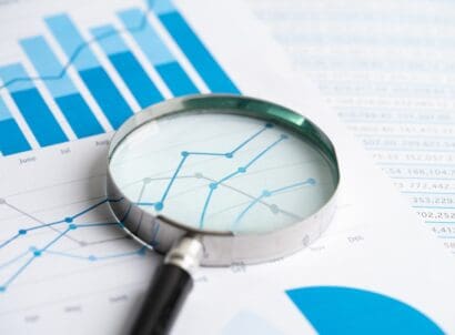 Magnifying,glass,on,graph,paper ,financial,development,,banking,account,,statistics,