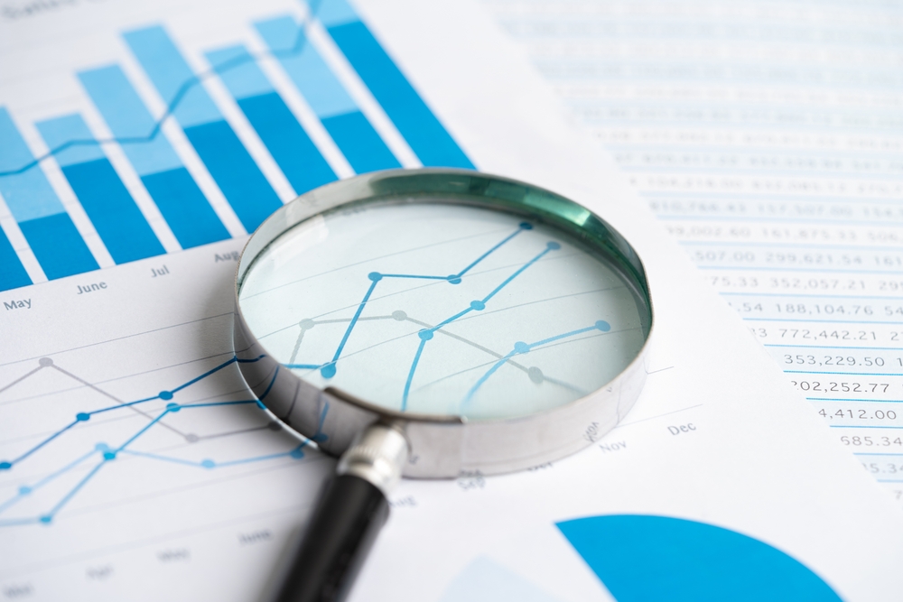 Magnifying,glass,on,graph,paper ,financial,development,,banking,account,,statistics,