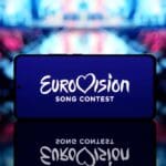 Smartphone,displaying,eurovision,song,contest,logo,with,a,blurred,stage