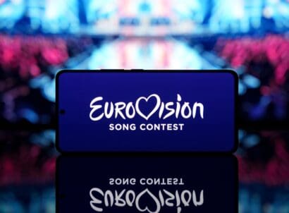 Smartphone,displaying,eurovision,song,contest,logo,with,a,blurred,stage
