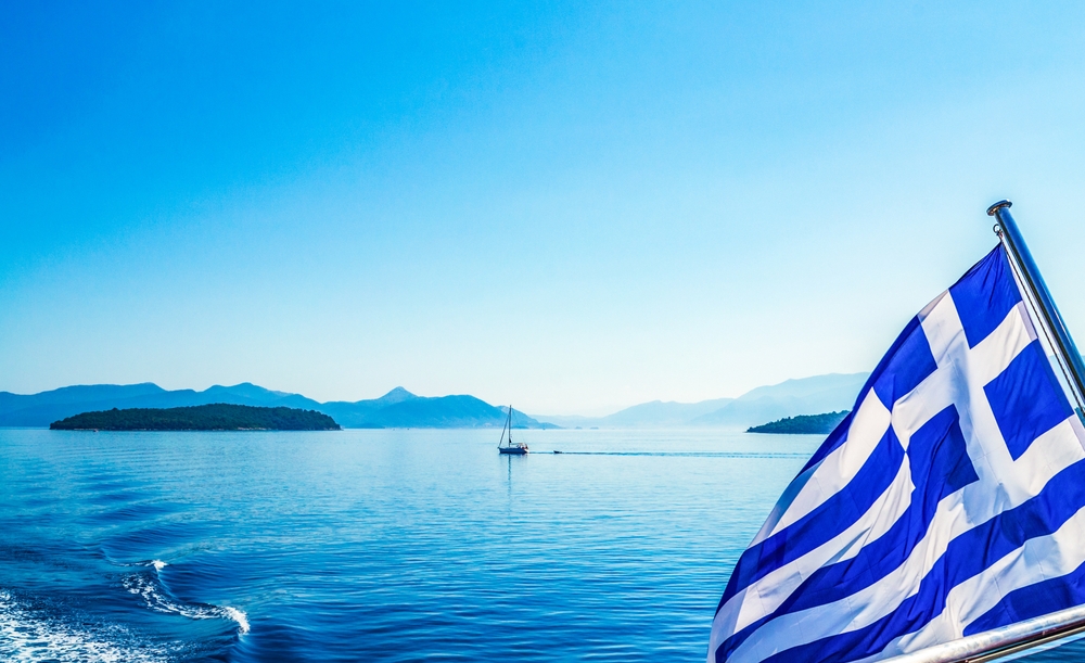 Greek,flag,blowing,on,sailing,boat,in,ionian,sea,greece